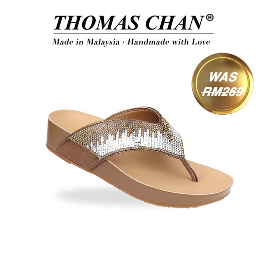 Diagonal view of Thomas Chan’s suede rhinestone flip-flops in bronze, showcasing soft suede straps embellished in sparkling rhinestones and LiteStep flatform footbed. The 'THOMAS CHAN®' brand is displayed below with 'Made in Malaysia · Handmade with Love.' A gold and white banner highlights a special offer: 'Was RM269'