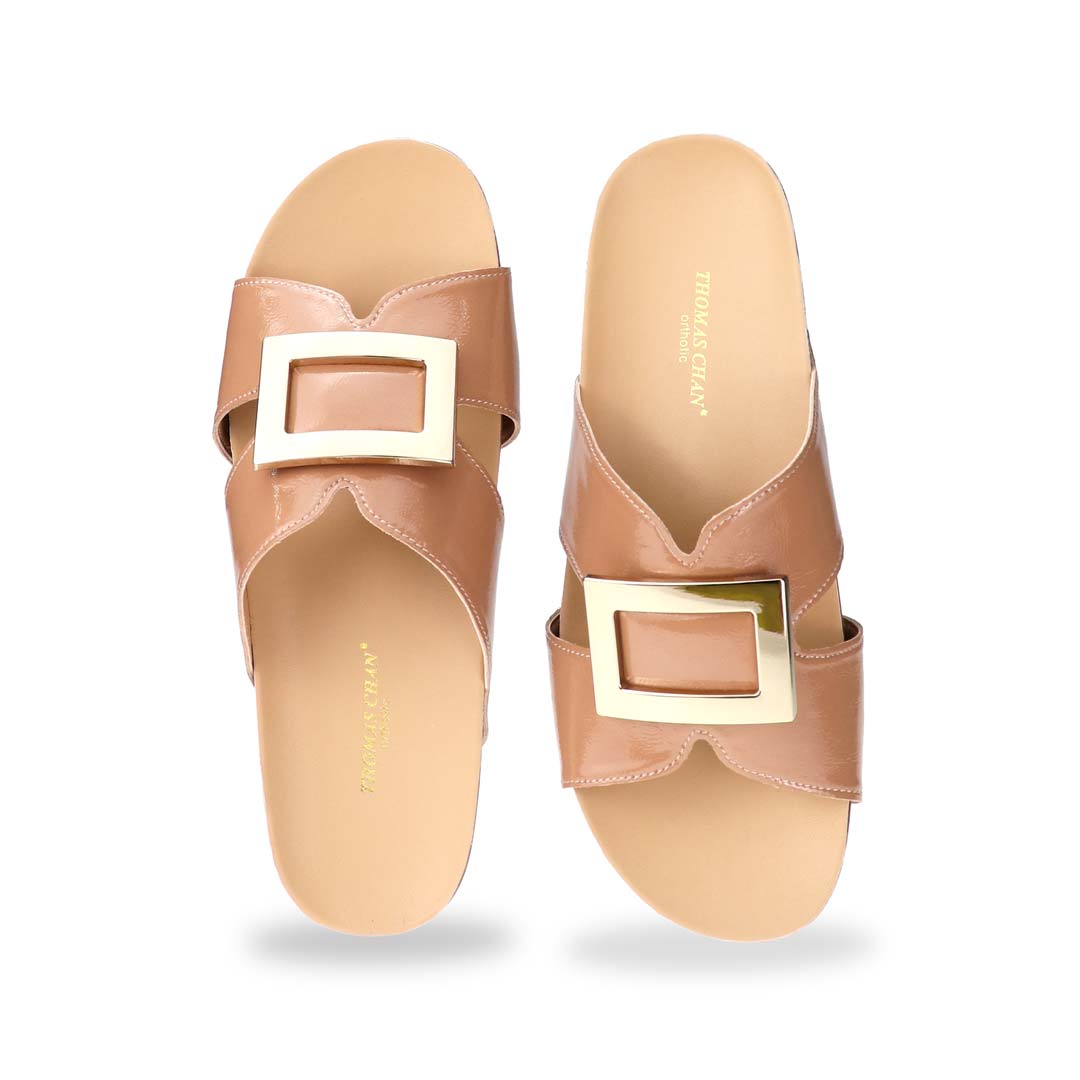 Front view of Thomas Chan LiteStep flatform sandals in nude patent leather, showcasing square gold buckle, on white studio background.