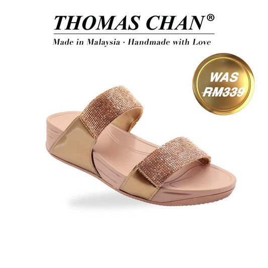 A diagonal view of the Diamond Embellished Duo-Strap Bounce Care Sandals in Bronze, highlighting the sparkling crystal-adorned straps and cushioned rubber sole. The slight elevation of the footbed is visible, offering both style and comfort against a neutral background. "THOMAS CHAN®" brand displayed with "Made in Malaysia · Handmade with Love" below. Gold and white banner highlights special offer: "Was RM339"