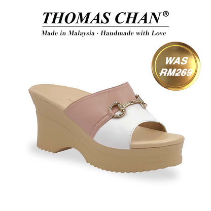Diagonal view of Thomas Chan Two-Tone Horsebit Buckle Wedge Heels  from Cushioned Heel Series, featuring a blush pink and white upper with a gold horsebit buckle accent, set on a beige cushioned platform sole. "THOMAS CHAN®" brand displayed with "Made in Malaysia · Handmade with Love" below. Gold and white banner highlights special offer: "WAS 269."