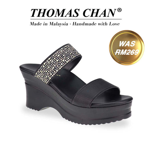 Diagonal view of Thomas Chan's Strappy Rhinestone Cushioned Heels in black: With a built-in cushioned footbed and a chic two-strap design, these heels offer a sleek front stripe complemented by a dazzling rhinestone strap at the back."THOMAS CHAN®" brand displayed with "Made in Malaysia · Handmade with Love" below. Gold and white banner highlights special offer: "Was RM269"