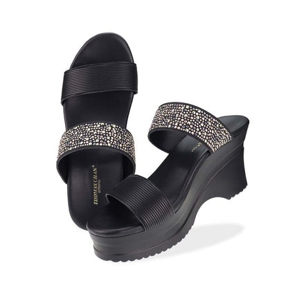 Full view of Thomas Chan's Strappy Rhinestone Cushioned Heels in black: With a built-in cushioned footbed and a chic two-strap design, these heels offer a sleek front stripe complemented by a dazzling rhinestone strap at the back.