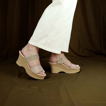 Model showcasing Thomas Chan's Strappy Rhinestone Cushioned Heels in cream. The heels feature a built-in cushioned footbed, a sleek front stripe, and a dazzling rhinestone strap at the back. Set against a bronze-colored backdrop, the image highlights the elegance and support of the design, in a standing position.
