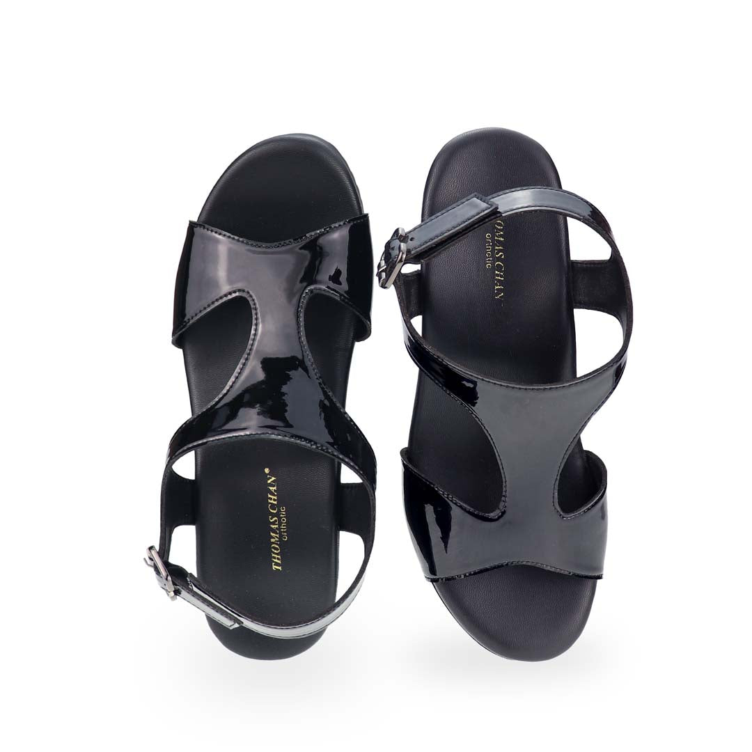 A close-up of the front, emphasizing the sleek pointed toe, polished patent leather, and timeless elegance.