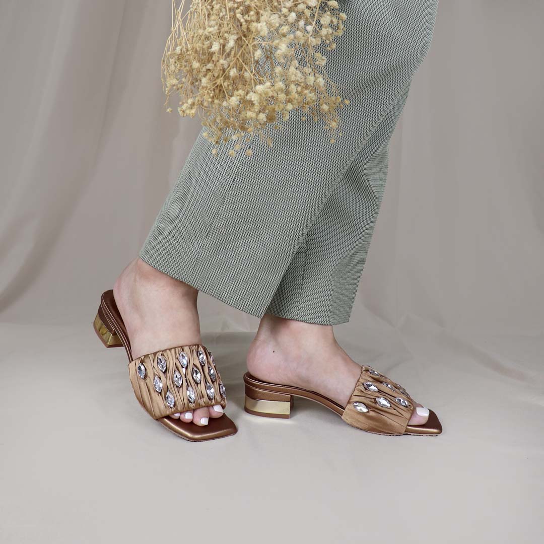 Model wearing Crystal Lux Satin Evening Heels in bronze indoors, showcasing the luxe satin finish and statement crystal details — stylish yet comfortable heels for weddings, events, or formal dinners.