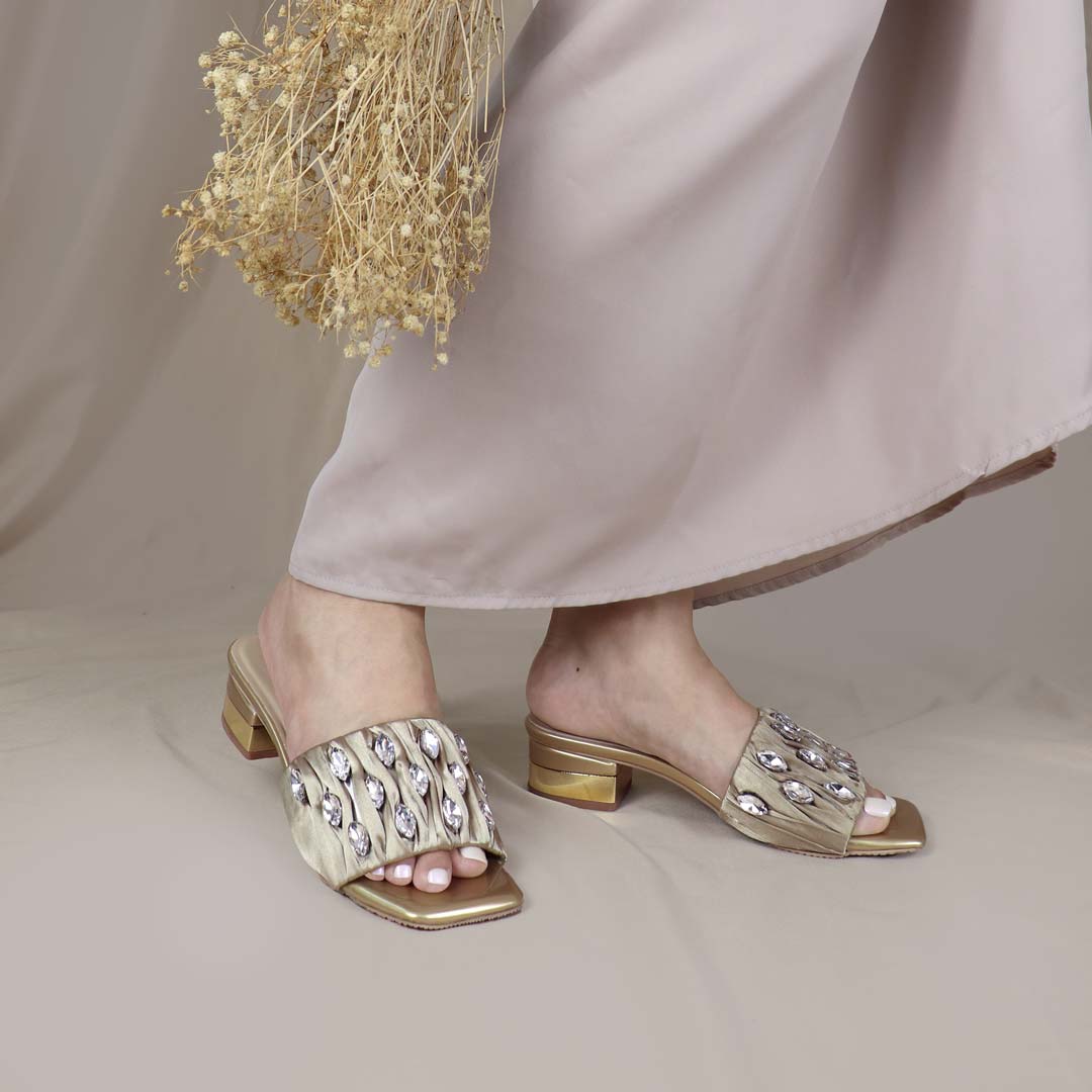 Model wearing Crystal Lux Satin Evening Heels in gold indoors, showcasing the luxe satin finish and statement crystal details — stylish yet comfortable heels for weddings, events, or formal dinners.