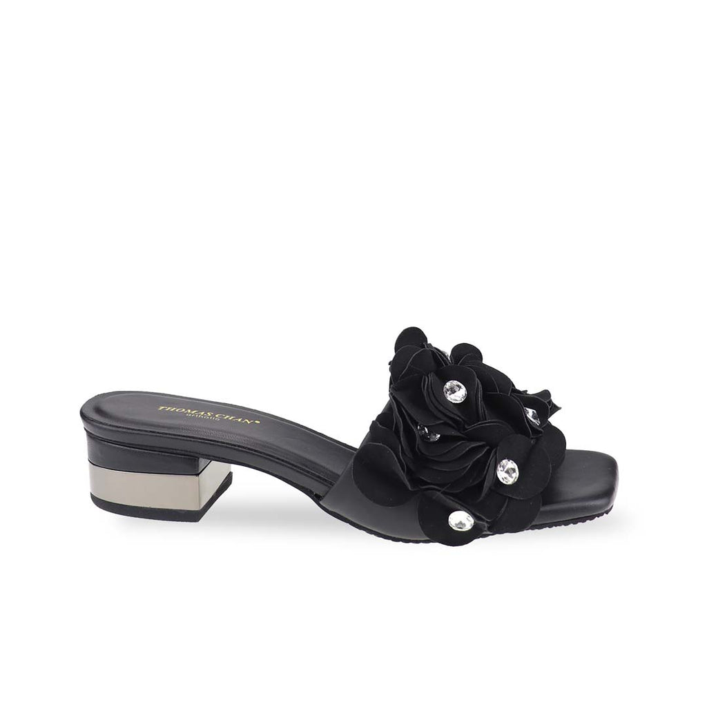Side profile of black Blooming Flower Evening Heels in a studio setting, highlighting the 3cm metal block heel and soft floral layers with rhinestones.