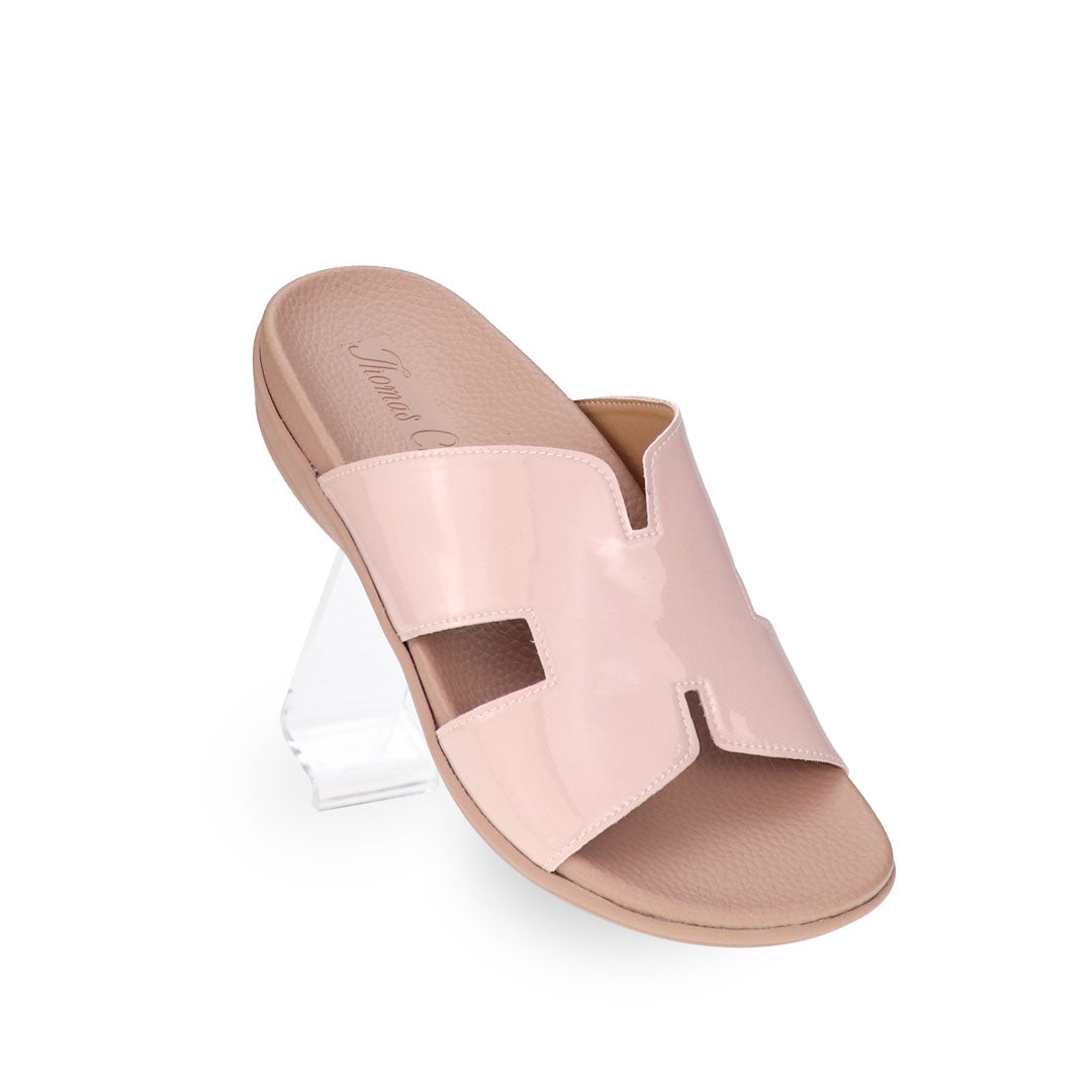 A close-up diagonal angle of Thomas Chan’s Extra Comfort H-Strap Flats in Nude Pink, showcasing the sleek H-strap design and glossy nude tone.