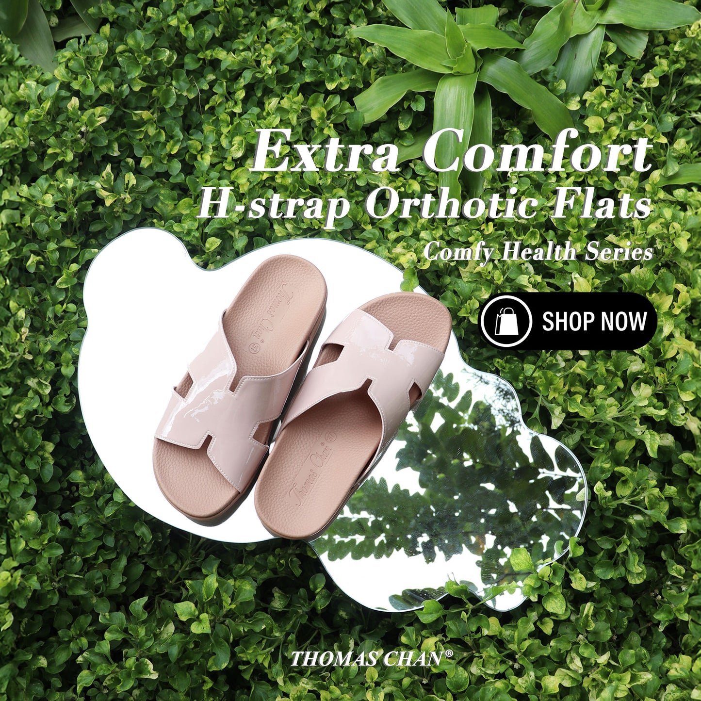 A pair of Thomas Chan’s Extra Comfort H-Strap Orthotic Flats in Nude Pink placed on an artistic, cloud-shaped mirror, reflecting green foliage. The flats feature a glossy H-strap design and an orthotic footbed. White text above highlights "Extra Comfort H-strap Orthotic Flats" from the "Comfy Health Series," with a "Shop Now" button on the right side. The "Thomas Chan®" brand name is displayed at the bottom.