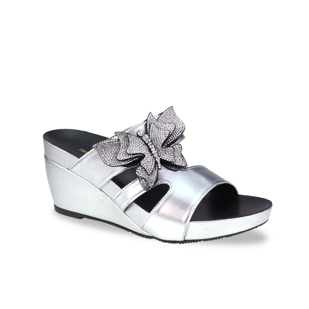 Thomas Chan’s Glimmer Butterfly Dinner Wedges in a diagonal studio view, showcasing the metallic silver finish, rhinestone butterfly detail, and 3-inch ArchLegance wedge.