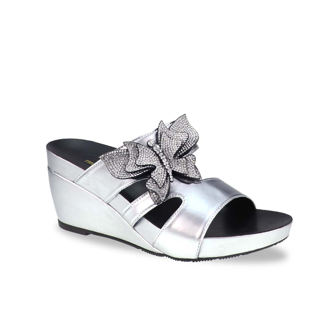 Thomas Chan’s Glimmer Butterfly Dinner Wedges in a diagonal studio view, showcasing the metallic silver finish, rhinestone butterfly detail, and 3-inch ArchLegance wedge.