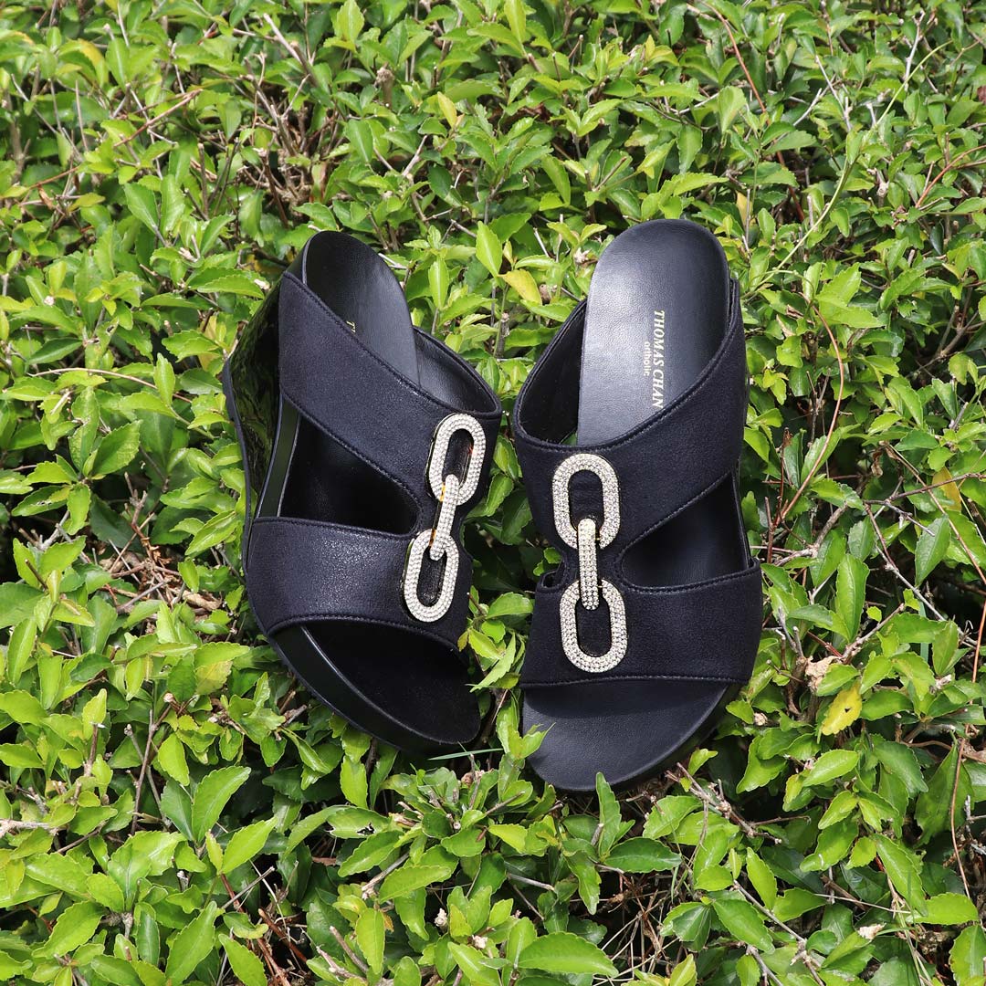 Aurora Chain High Wedges by Thomas Chan with diamond chain buckles and shimmering fabric, 3-inch arch support wedges displayed on lush green foliage.