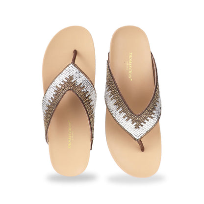 Studio shot of bronze suede rhinestone flip-flops showing the full front design with sparkling rhinestone straps and smooth cushioned sole.