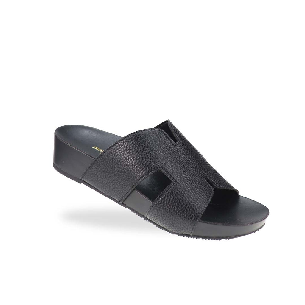 A stylish angle of the H-Strap Pebble Lychee Flatform Sandals in black, highlighting the textured material and smooth, cushioned footbed for all-day comfort.