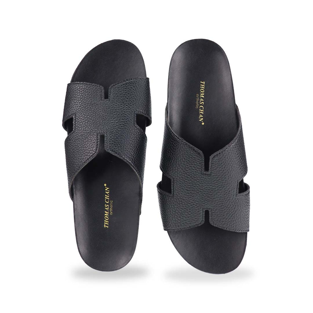  A direct front shot of the H-Strap Pebble Lychee Flatform Sandals in black, showcasing the structured yet soft H-strap and ergonomic footbed.