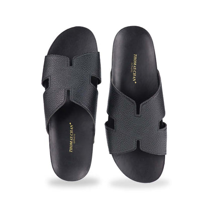  A direct front shot of the H-Strap Pebble Lychee Flatform Sandals in black, showcasing the structured yet soft H-strap and ergonomic footbed.