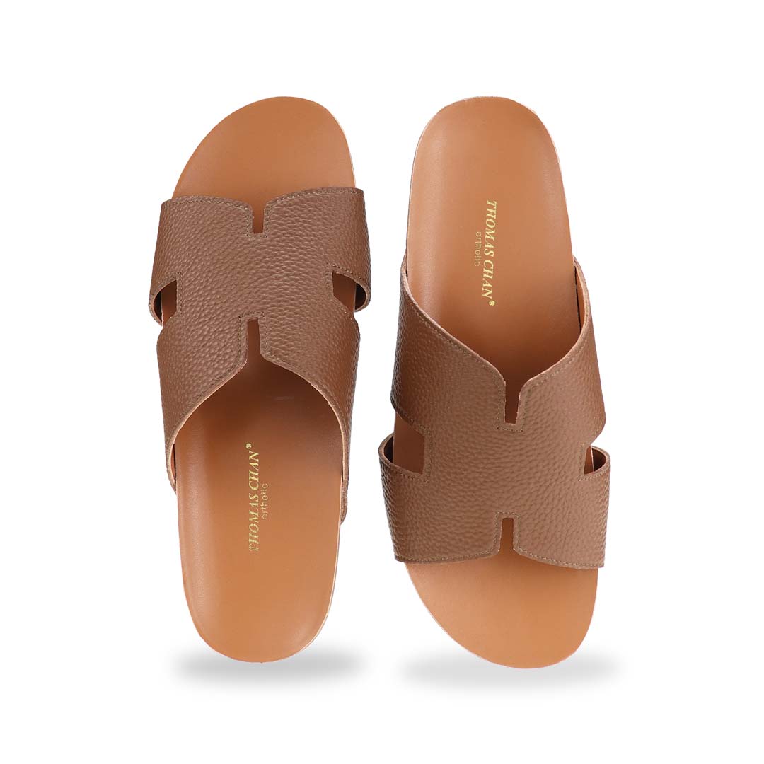  A direct front shot of the H-Strap Pebble Lychee Flatform Sandals in brown, showcasing the structured yet soft H-strap and ergonomic footbed.