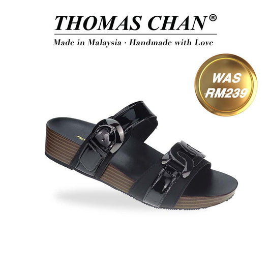 Diagonal view of Thomas Chan’s Metallic Duo-Strap Adjustable Sandals in black, showcasing sleek metallic straps, an adjustable buckle for a perfect fit, and a LiteStep flatform footbed for added comfort. The 'THOMAS CHAN®' brand logo is prominently displayed, with the inscription 'Made in Malaysia · Handmade with Love' beneath it. A gold and white banner highlights the special offer: 'Was RM239.'