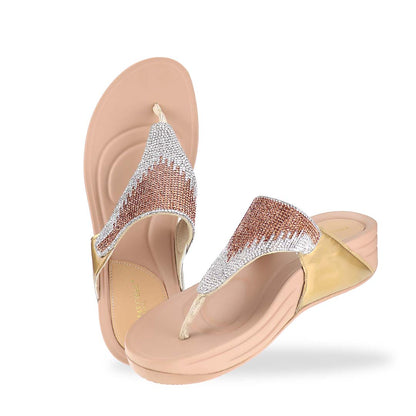 A full top-down view of the Diamond Embellished Flip-Flop Sandals in gold placed on a natural outdoor surface. The symmetrical crystal embellishments on the straps and the neutral-toned flatform sole create an elegant yet comfortable footwear look.
