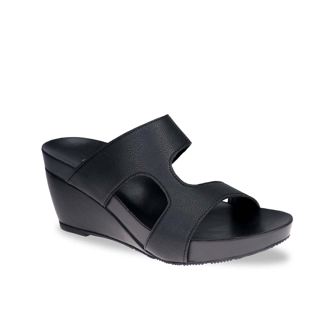 Thomas Chan Simplicité High Wedges photographed in studio at diagonal angle — matte black minimalist sandals with clean curves and comfortable 3-inch wedge heel.