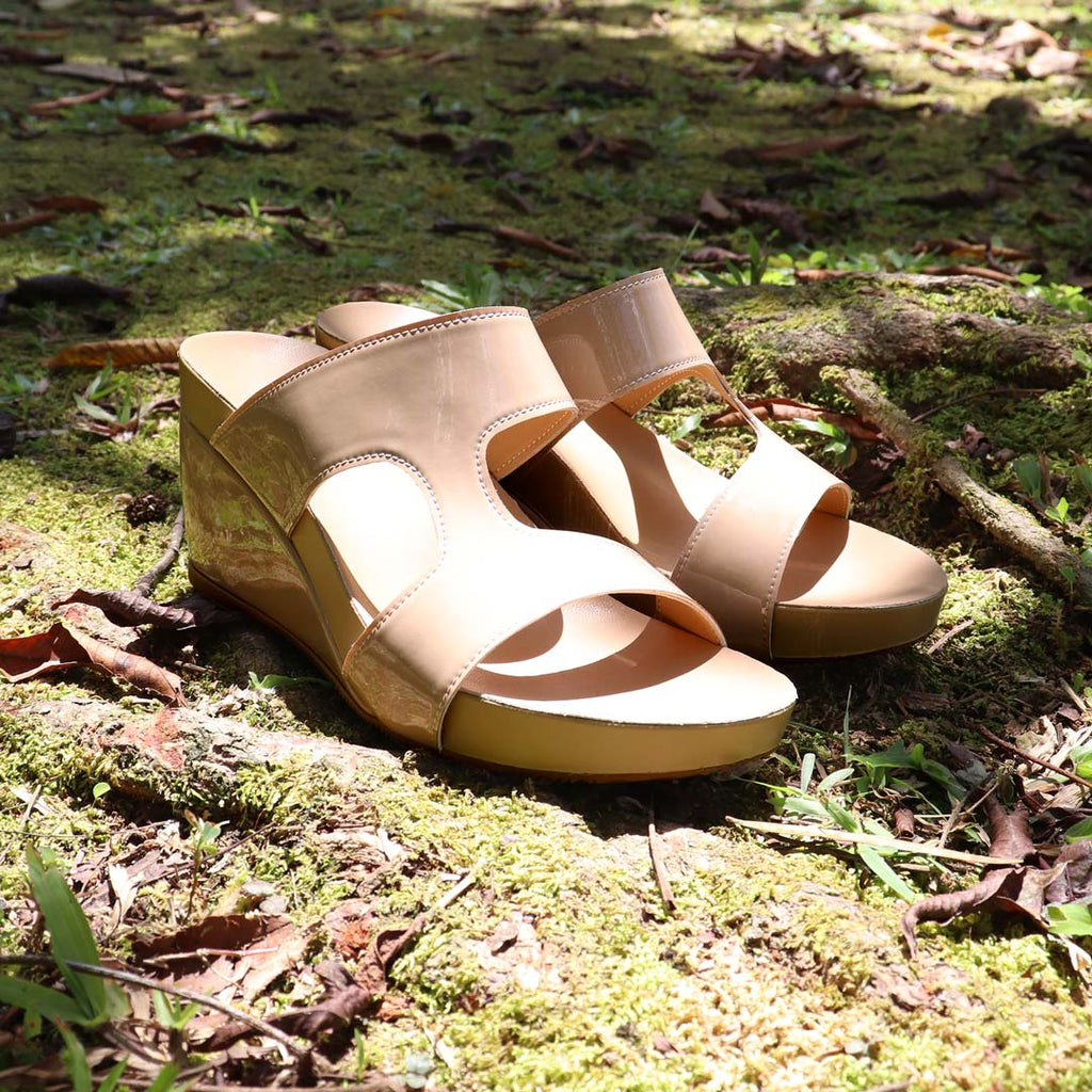 Thomas Chan Simplicité High Wedges in nude beige photographed outdoors on mossy forest ground — minimalist high wedges with 3-inch heel and glossy finish, perfect for effortless elegance and comfort.