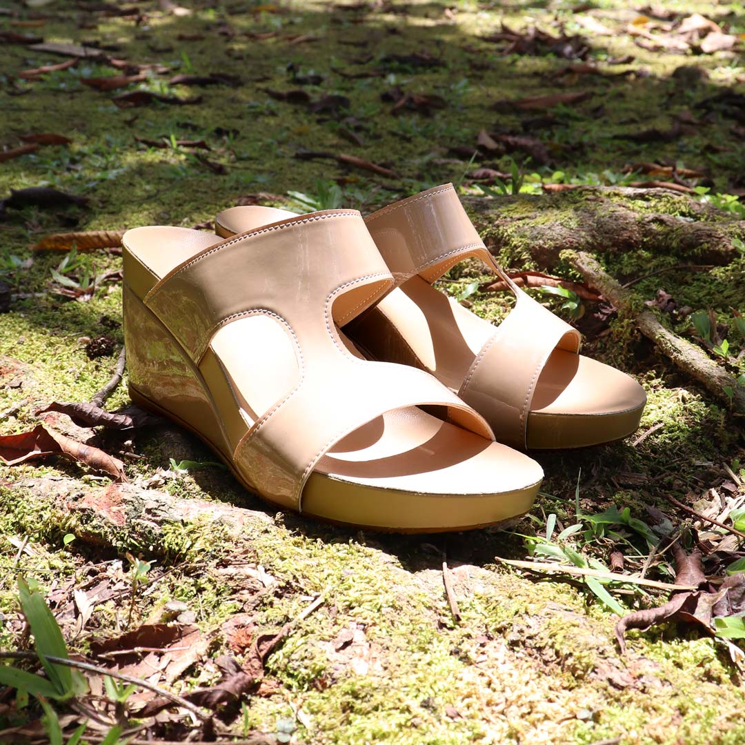 Thomas Chan Simplicité High Wedges in nude beige photographed outdoors on mossy forest ground — minimalist high wedges with 3-inch heel and glossy finish, perfect for effortless elegance and comfort.